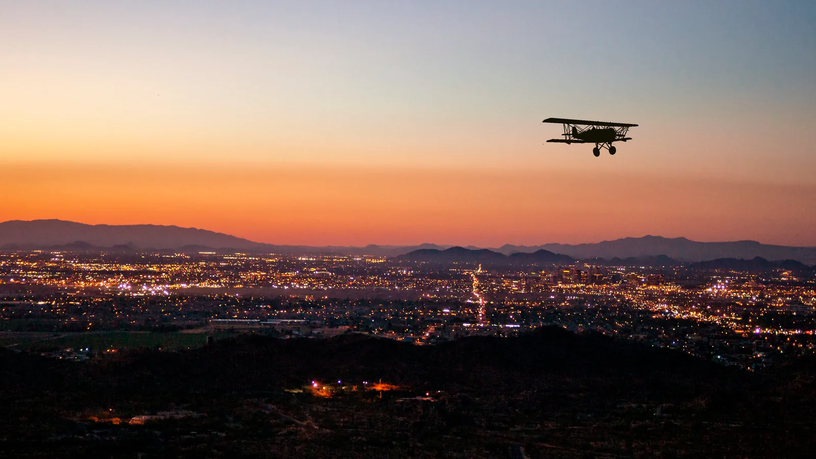 A landscaped setting photographed at dusk with lights coming on